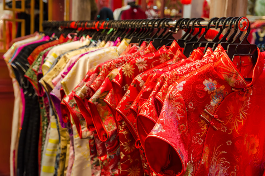 Wear something new on February 1, 2022. Colorful Chinese cheongsam hanging for sale during Chinese New Year.